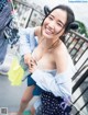 A woman in a blue shirt and polka dot shorts posing for a picture.