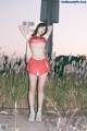 A woman in a red and white cheerleading uniform posing for a picture.