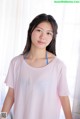 A young woman in a pink shirt posing for a picture.