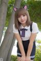 A young woman in a school uniform posing for a picture.