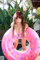 A woman in a pink donut shaped pool float.