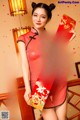 A woman in a red cheongsam holding a red envelope.