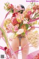 A woman in a thong holding a bunch of flowers.